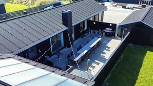 A rooftop patio with outdoor seating and a glass enclosure. - 4 Star Holiday Home in Blokhus (Blokhus)