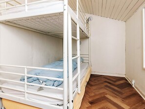 A bunk bed room with a wooden herringbone floor and white walls. - 4 Star Holiday Home in Blokhus (Blokhus)