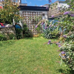 A garden with a grassy area, various plants, and a wall with a lattice design. - Colourful family home London zone 2 - Lewisham (London)