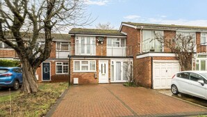 A two-story residential building with a brick facade, a central entrance, and a driveway leading to a garage. - Close to Windsor, Heathrow and central London — sleeps nine (Berkshire)