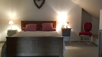 Una camera da letto con un letto di legno, una decorazione a forma di cuore, una sedia rossa e due lampade da comodino.
