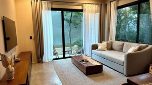 A modern living room with a sofa, coffee table, and a TV. - Modern duplex with private pool + 2 bicycles / 7 minutes from Tulum Beach (Tulum)