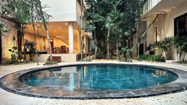 A pool surrounded by tropical plants and a seating area with a staircase leading to an upper level. - Modern duplex with private pool + 2 bicycles / 7 minutes from Tulum Beach (Tulum)