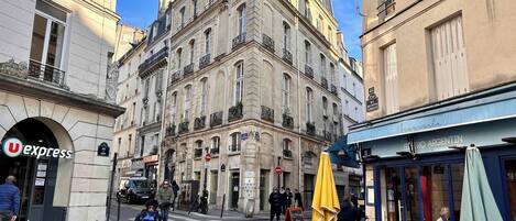 A street view with a building featuring a 'PIZZA' sign, a 'U express' shop, and a 'Bistro Argentin' restaurant.