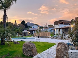 A modern house with a swimming pool, surrounded by a well-maintained garden and large rocks. - Luxury villa in Sardinia for 8 people with private pool, garden and wifi (Sardegna)