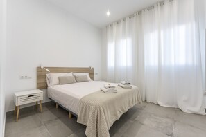 A bedroom with a bed, bedside table, and curtains. - Apartment 'Arena Suite Fuengirola' with Wi-Fi and Air Conditioning (Fuengirola)
