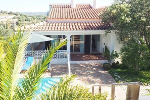 A house with a tiled roof, a swimming pool, and a covered patio area. - Villa Casa Kuito - Estoi (Estói)