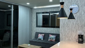 Un salon moderne avec un canapé, une table basse et des luminaires suspendus.