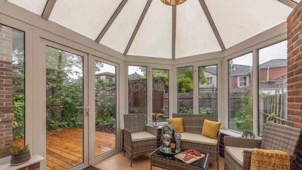 A conservatory with wicker furniture, a glass table, and a view of a garden. - 3BR Luxury Chic Spacious House w/Parking -Sleeps 7 (Southampton)