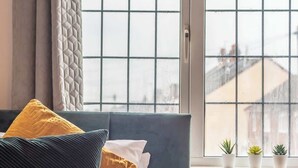 A bed with a dark headboard, a yellow blanket, and multiple pillows. - 3BR Luxury Chic Spacious House w/Parking -Sleeps 7 (Southampton)