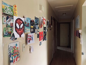 A hallway with various posters and decorations, including Spider-Man themed items.