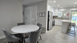 A modern kitchen with white cabinets, a built-in oven, and a stainless steel refrigerator. - Cozy 2BD/1BA Near Beach + Fast I-95 Access! (Hallandale Beach)