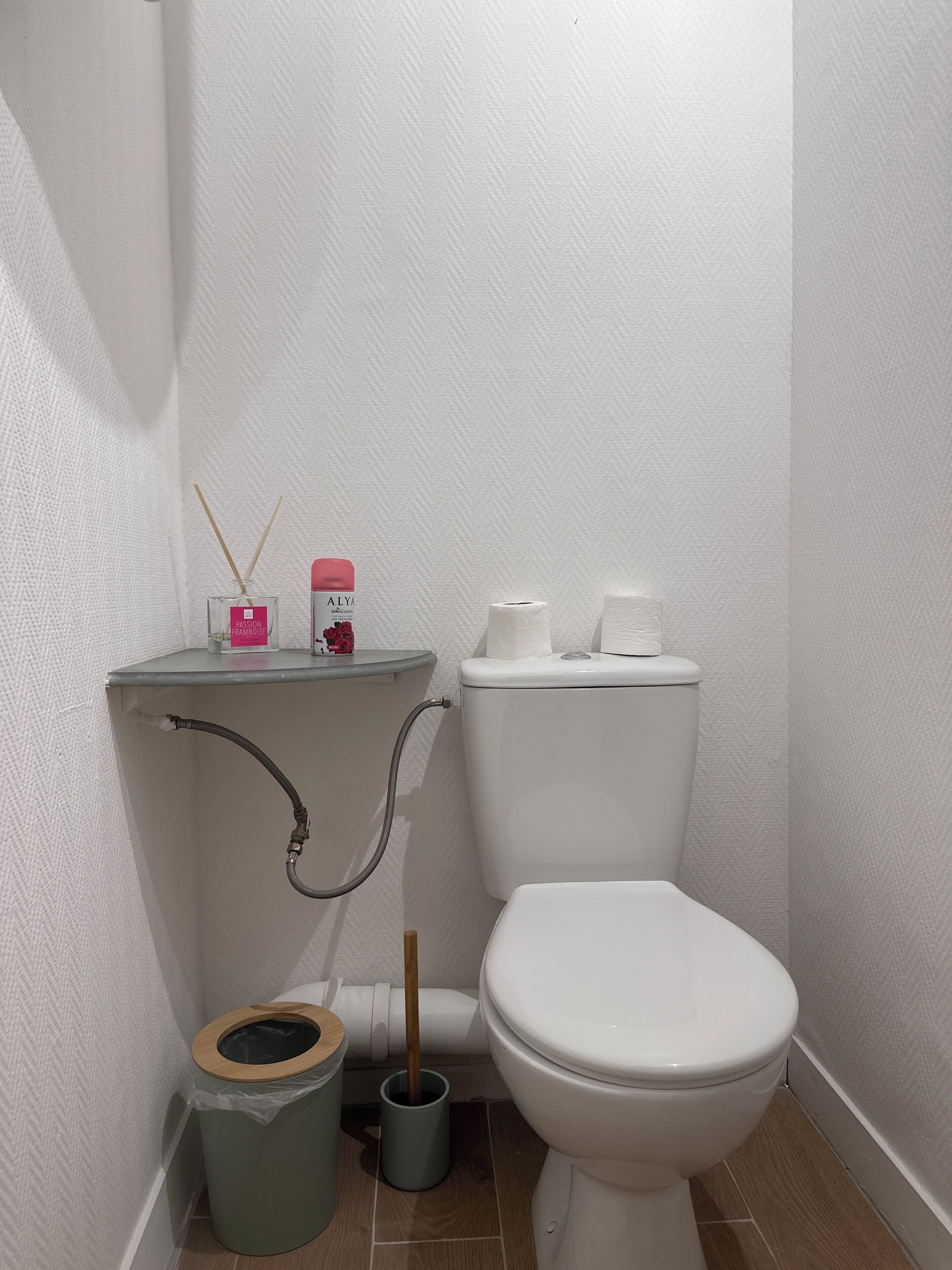 A small, clean bathroom with a toilet, bidet, and a trash bin.