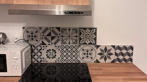A kitchen with a microwave, a stove, and a cabinet. - Appartement 2 Chambres Business Famille (Orléans)