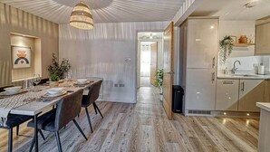 Un interior moderno con comedor, cocina y un pasillo.
