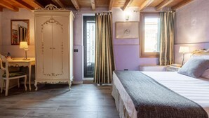 Une chambre à coucher comprenant un lit, une table de chevet, une lampe, une armoire et un bureau avec une chaise.