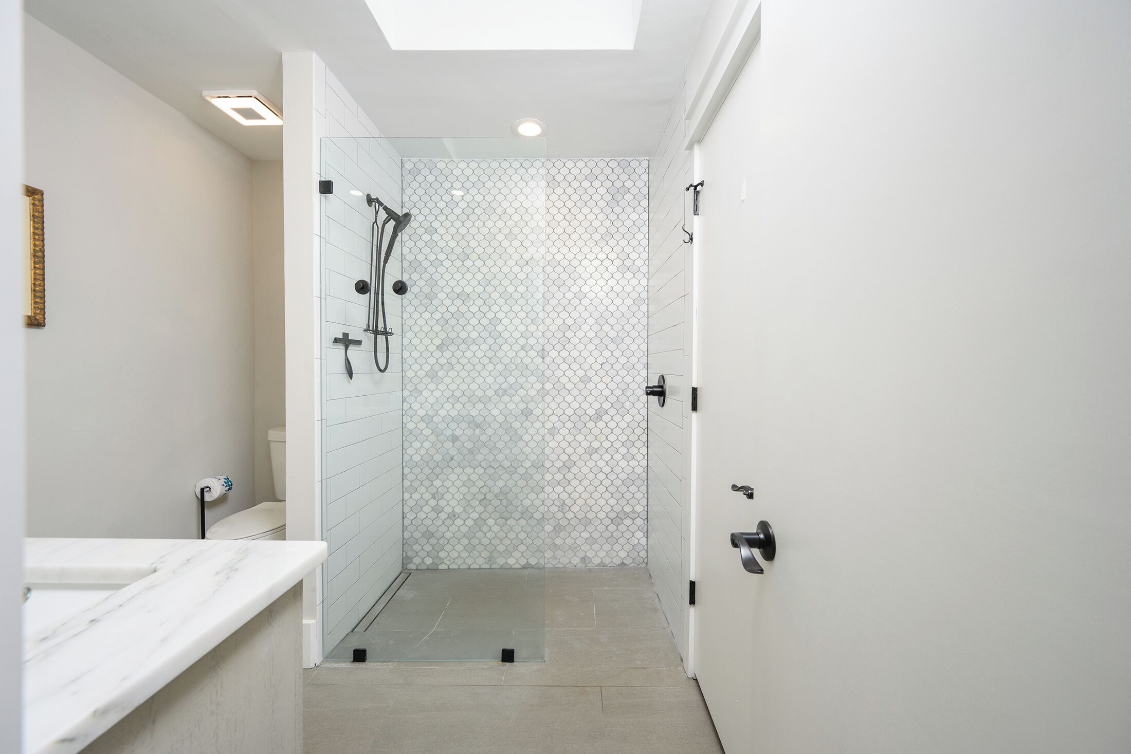 Un baño moderno con ducha, inodoro y lavamanos.