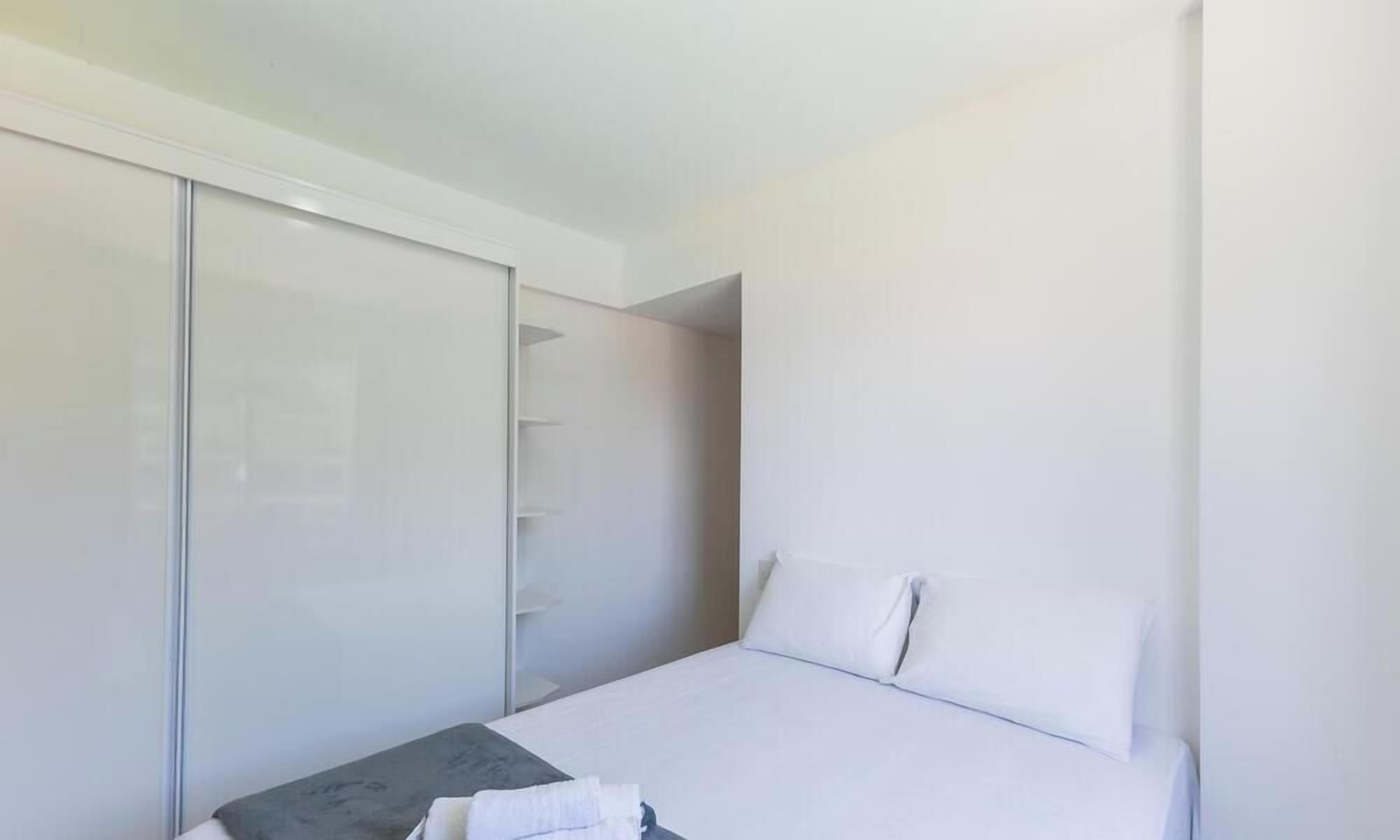 Un dormitorio con cama, mesita de noche y armario.
