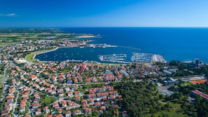 An aerial view of a coastal town with residential areas, a marina, and a large body of water. - Cozy Flat in Central Umag (Umag)