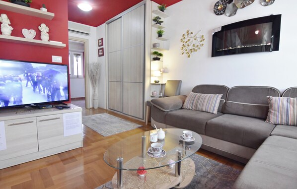 A living room with a sofa, a glass coffee table, and a flat-screen TV. - Cozy Flat in Central Umag (Umag)