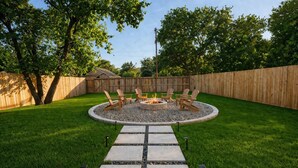 A backyard with a fire pit, outdoor seating, and a stone pathway. - Stonewood Cottage  Magnolia/Baylor/Downtown Waco (Waco)