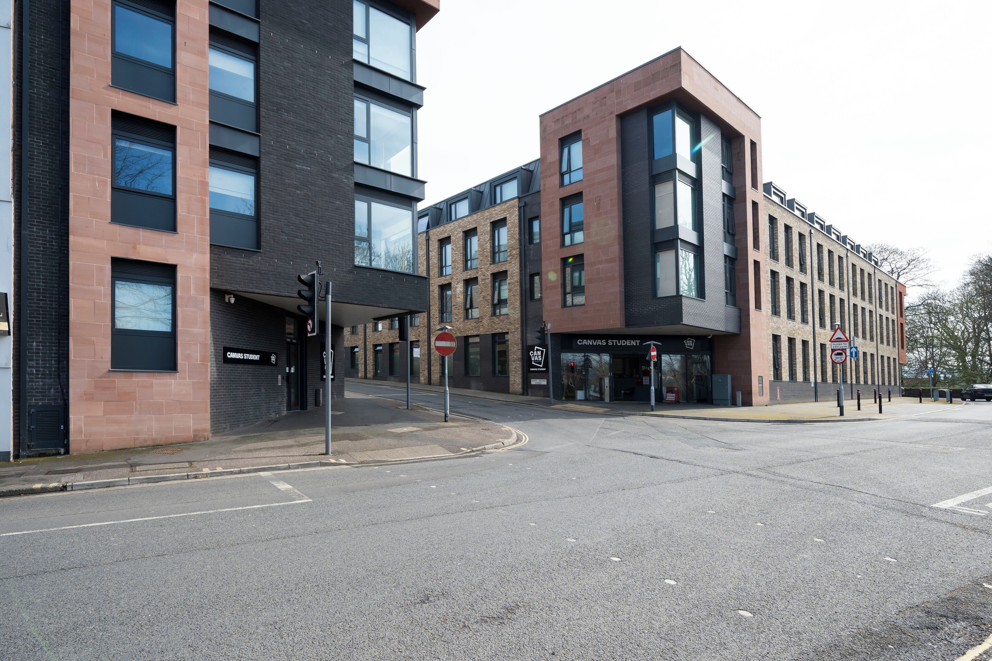 A modern building with multiple floors, large windows, and a prominent entrance.