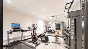 Uma academia com esteiras, elípticos e equipamentos de musculação.
