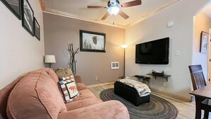 A living room with a sofa, a ceiling fan, a flat-screen TV, and a lamp. - CBL 3306 (Brian Head)