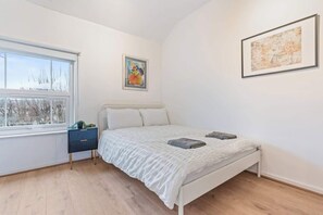 A bedroom with a bed, a window, a bedside table, and two framed artworks on the wall. - Perfect for Contractors | Central Location | Wi-Fi (Nottingham)