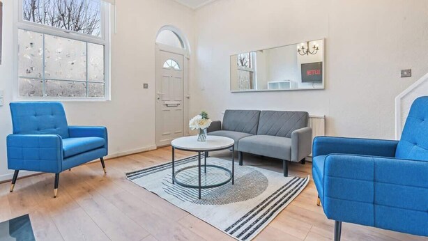 A living room with a sofa, two armchairs, a coffee table, a mirror, and a door. - Perfect for Contractors | Central Location | Wi-Fi (Nottingham)