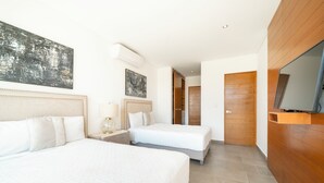 Ein Hotelzimmer mit zwei Betten, einem Fernseher und Bildern an den Wänden.