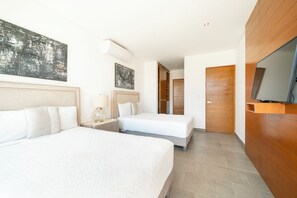 Ein Hotelzimmer mit zwei Betten, einem Fernseher und Bildern an den Wänden.