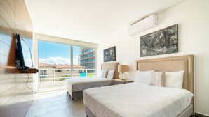 Ein Hotelzimmer mit zwei Betten, einem großen Fenster und Blick auf Gebäude.