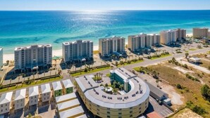Ein Küstenhotel mit mehreren Hochhäusern, einer zentralen kreisförmigen Struktur und Blick auf den Strand.