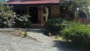 A building with a red roof and a stone-paved entrance. - A hidden ecological gem, a private Villa, in Salcedo, Dominican Republic (Salcedo)