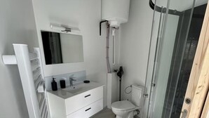 Une salle de bain moderne équipée de toilettes, d’un lavabo et d’une douche.