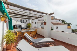 A rooftop terrace with a table, chairs, a grill, and potted plants. - Casa Bengeo - Two Bedroom Apartment, Sleeps 4 (Nerja)