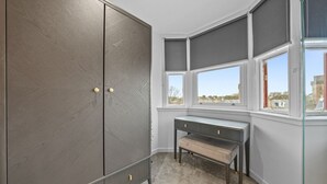 Una habitación con un armario grande, un escritorio y una ventana con vistas.