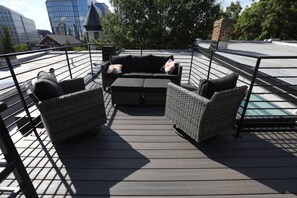 A rooftop deck with wicker furniture, a small table, and a view of the cityscape. - Downtown home w/free on-street parking & rooftop (Washington)
