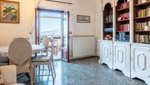 Un coin repas comprenant une table et des chaises, un radiateur et une bibliothèque contenant divers objets.