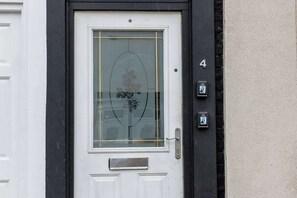 Eine weiße Tür mit einem Glasfenster und einem kleinen Briefkasten darunter.