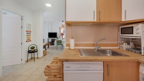 A kitchen with wooden cabinets, a built-in dishwasher, a sink, and a microwave.
