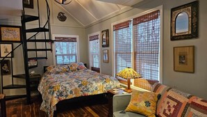 Un dormitorio con una cama, una silla, una lámpara y una ventana con vistas.