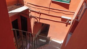 Un escalier étroit avec des rampes métalliques menant à un palier.