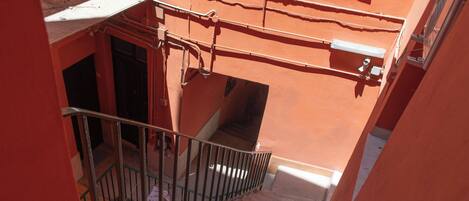 A narrow stairway with metal railings leading to a landing.