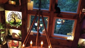 Un intérieur en bois agrémenté d’un lustre circulaire, de nombreuses fenêtres et de plantes d’intérieur.
