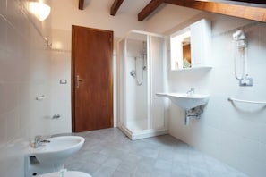 Un baño con ducha, dos lavamanos y una puerta de madera.