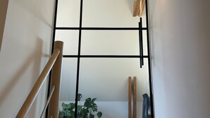 Een moderne trap met een houten leuning en een glazen balustrade.