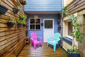 A wooden deck with two Adirondack chairs, a small table, and potted plants. - Ti kouign amann - Proche du Port (Douarnenez)