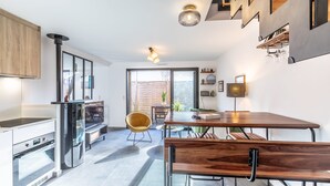 Eine moderne Küche mit Essbereich, ausgestattet mit einem Holztisch, Stühlen und einem Einbauofen.